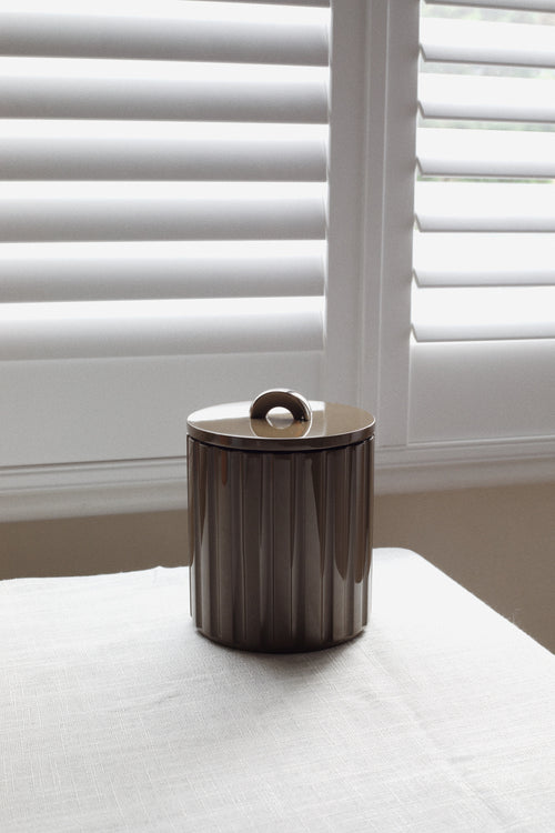 Deep espresso fluted lacquer ice bucket styled on linen for warm autumn bar cart and tablescape design.