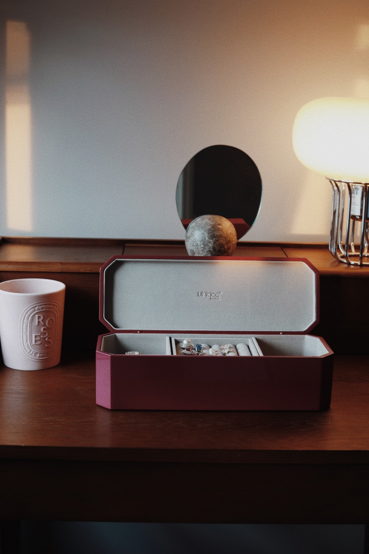 Vinidec octagonal jewellery box in open mulberry lacquer with velvet interior compartments, styled on a wooden vanity table