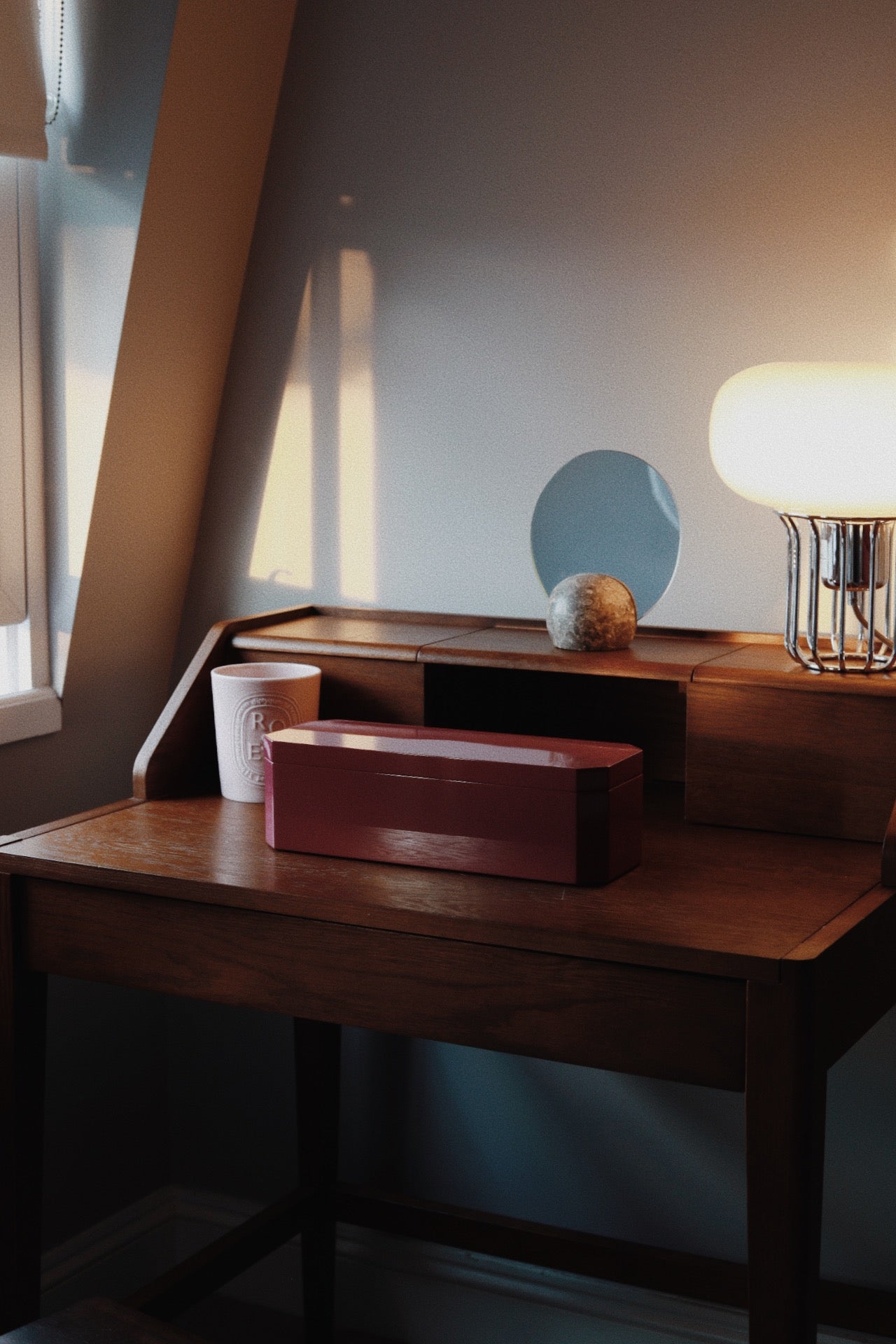 Vinidec octagonal glossy mulberry lacquered jewellery box, styled on a mid-century wooden vanity desk beside a glowing table lamp